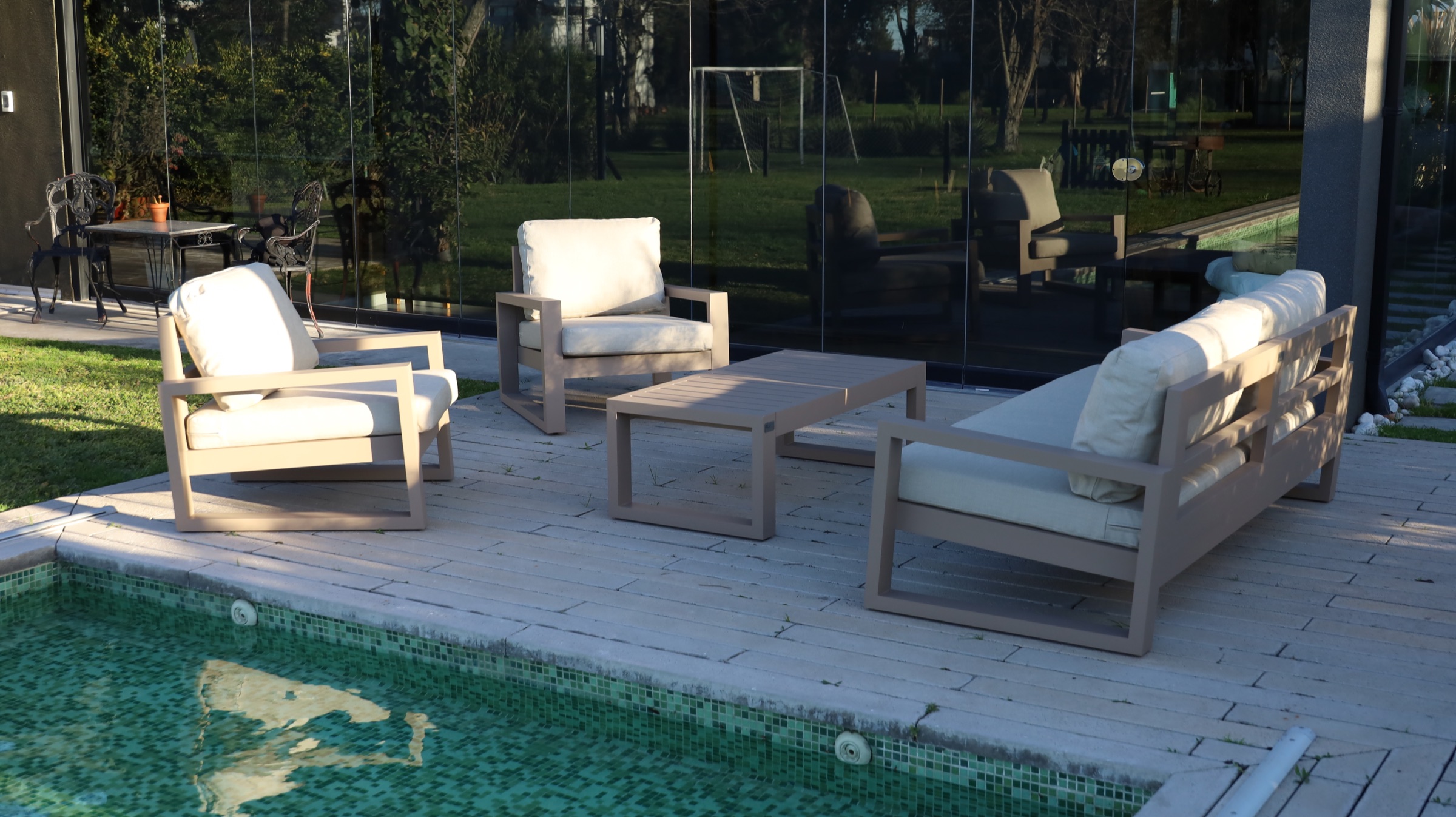 Juego de living exterior en arena junto a la pileta